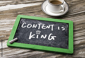 Une ardoise sur laquelle est écrit “Content is king” et un café